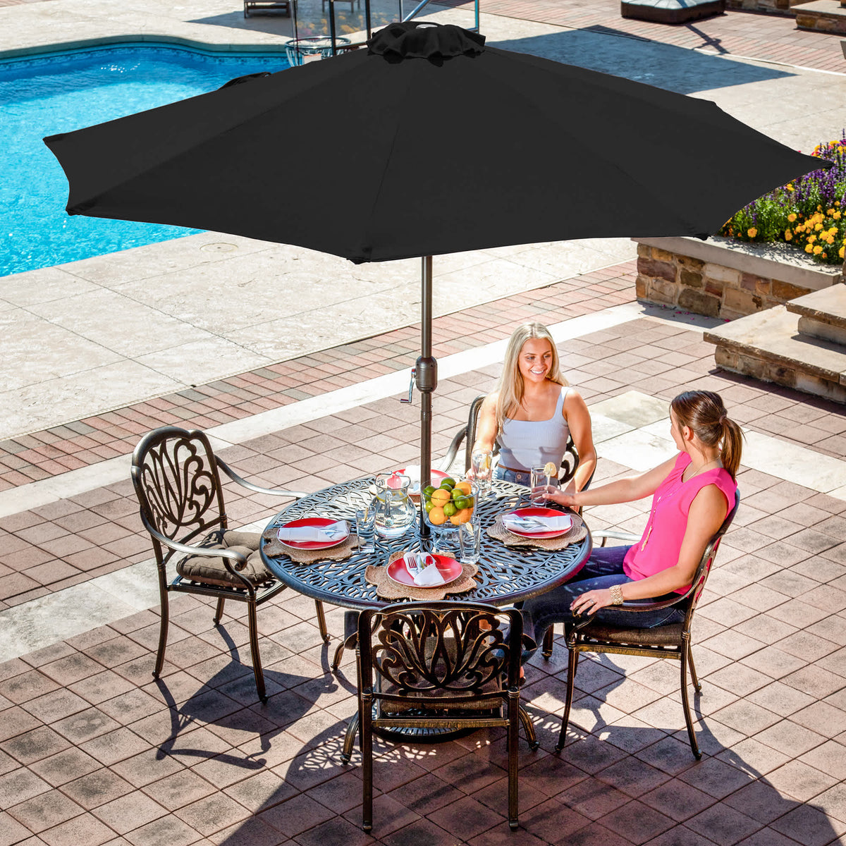 Island Umbrella Mirage Auto-Tilt Umbrella - black canopy over a poolside dining table in use