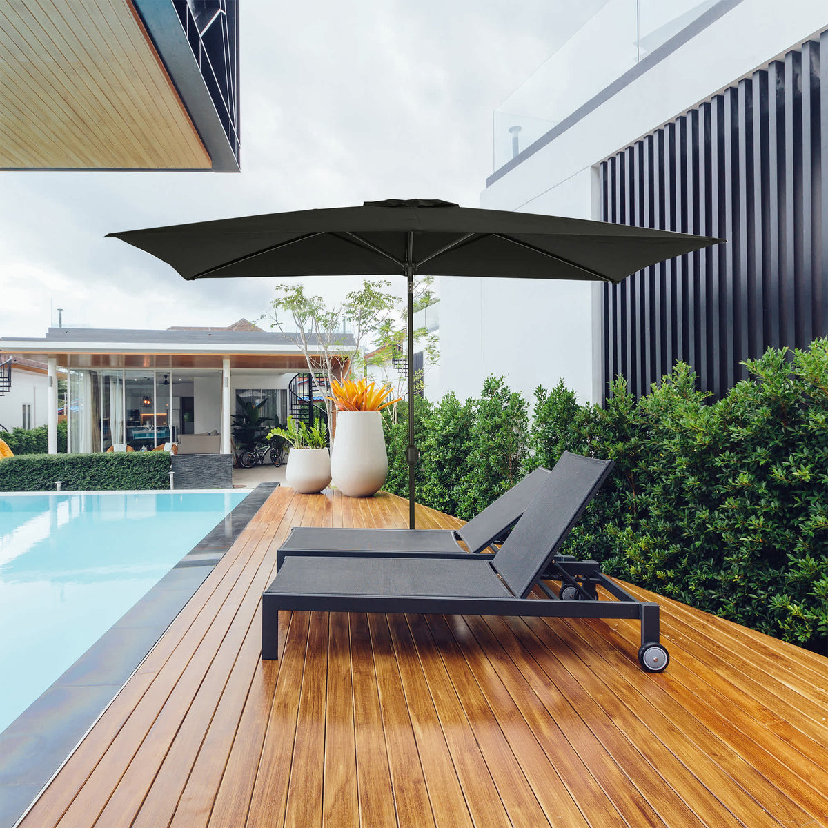 Island Umbrella Bimini Rectangular Market Umbrella - black canopy shading a lounger by a pool