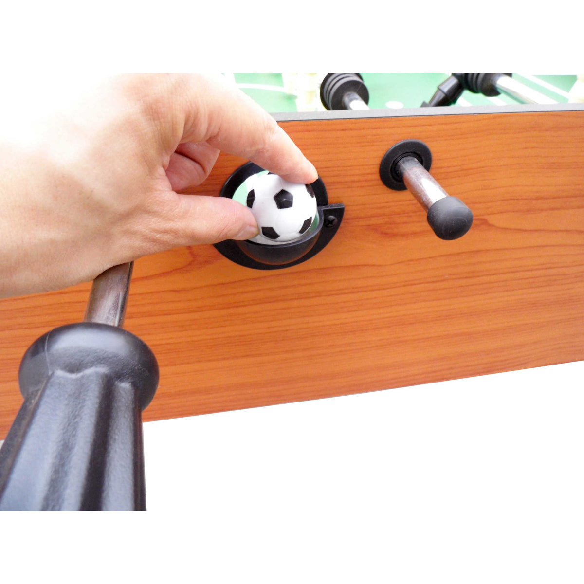 Hathaway Hurricane Foosball Table - hand dropping a soccer ball into the side serve hole