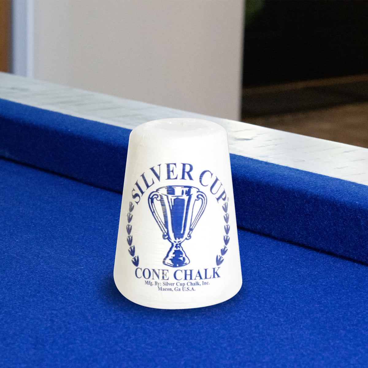 Silver Cup Cone Talc Chalk - cone standing on the rail of a blue-felt pool table