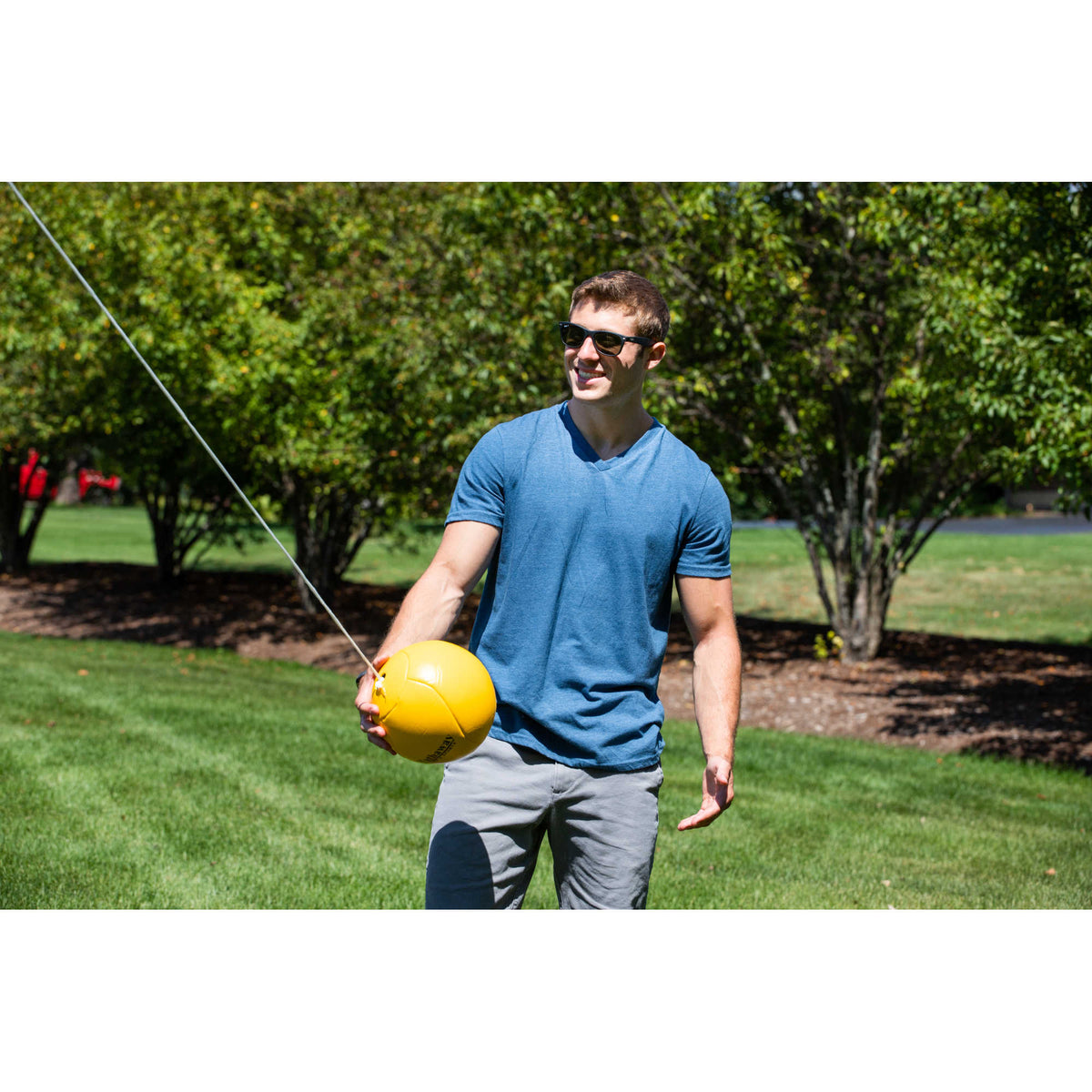 Hathaway Tetherball Set - player holding the yellow tetherball on its rope before serving