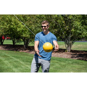 Hathaway Tetherball Set - player catching the yellow ball on its rope beside the pole