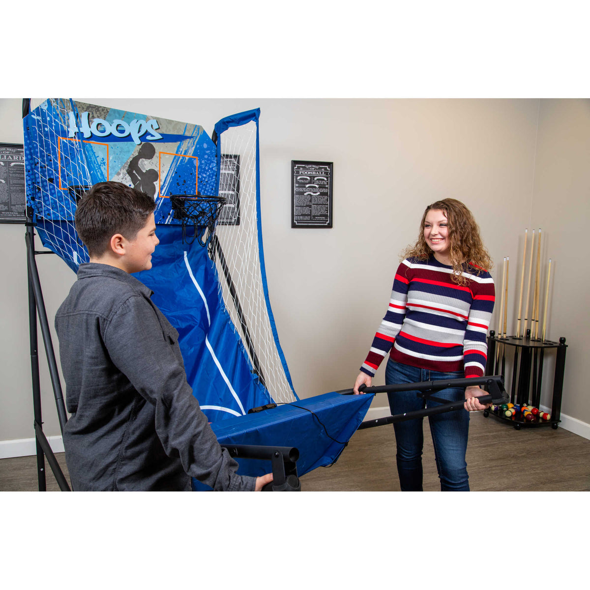 Hathaway Hoops Dual Basketball Arcade - two people folding the ball rack down for storage