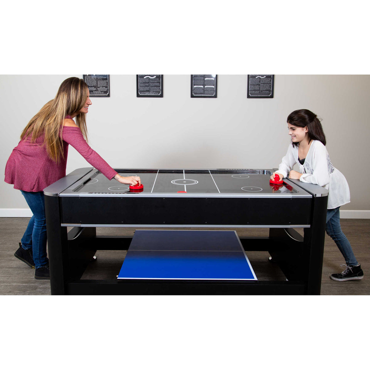 Hathaway Triple Threat Multi-Game Table - two players at the air hockey surface, tennis top stowed