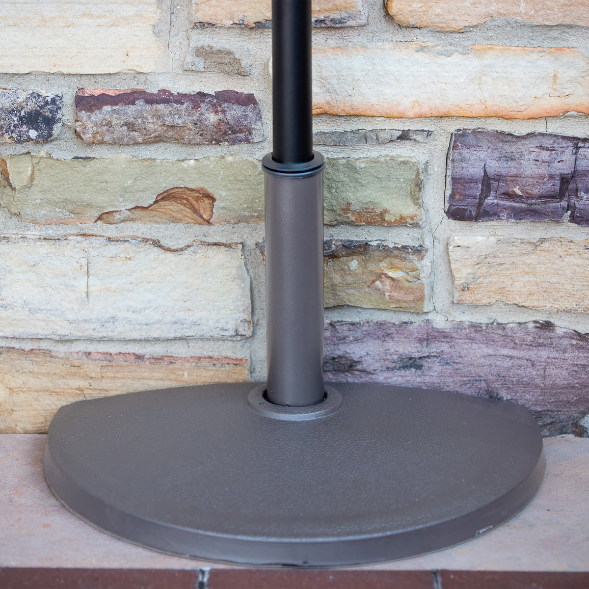 Island Umbrella 20-lb Half Umbrella Base - base against a stone wall with the pole seated