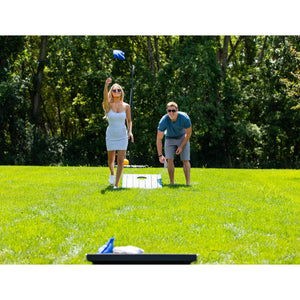 Hathaway Atlantic LED Cornhole Set - two players pitching bags at the board on a lawn