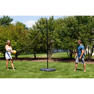 Hathaway Tetherball Set - two players at the pole on a lawn with the ball on its rope