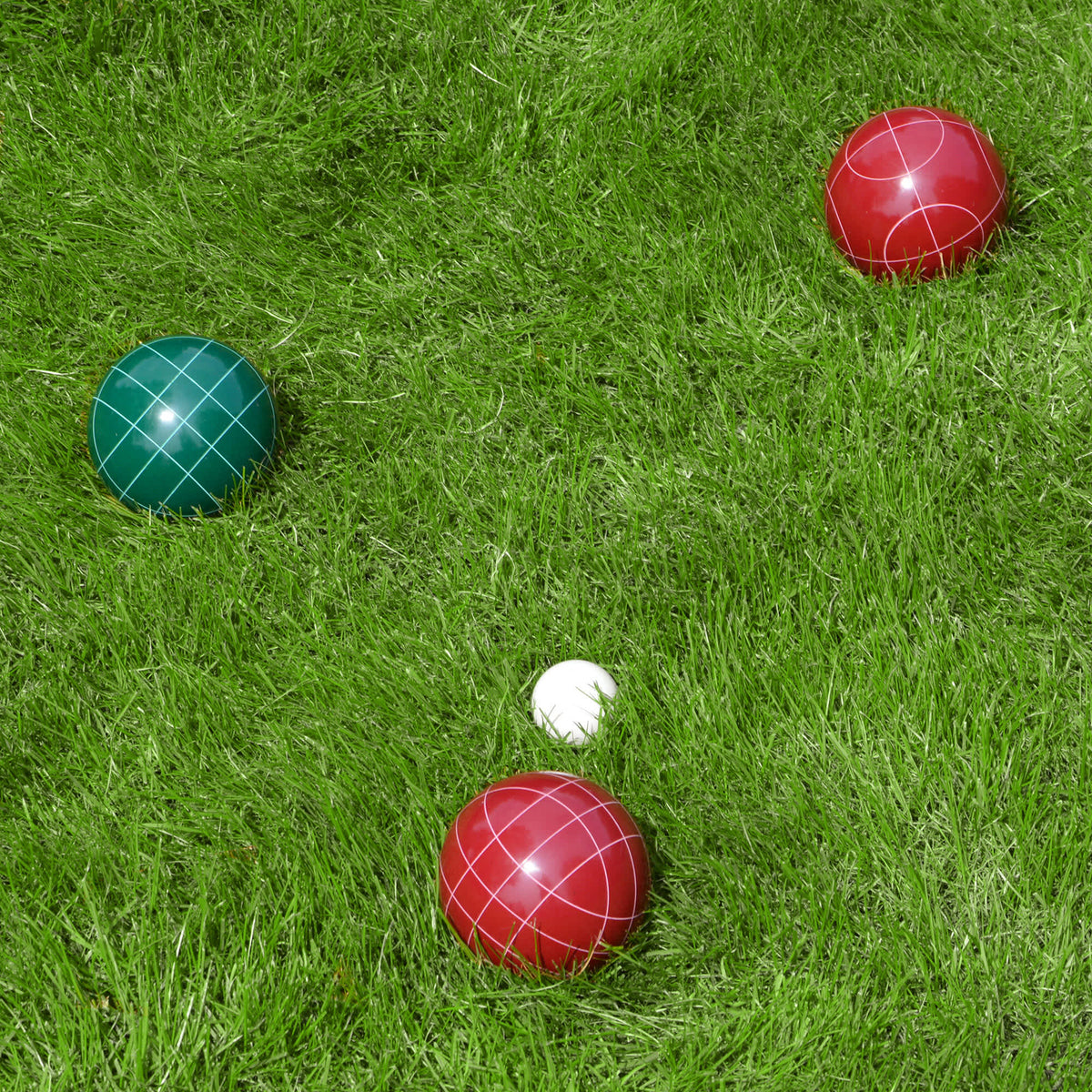 Hathaway Bocce Ball Set - red and green balls and the white pallino at rest on a lawn