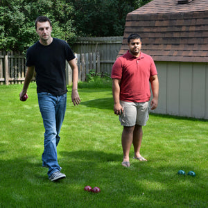 Hathaway Bocce Ball Set - two players bowling the set on a back garden lawn