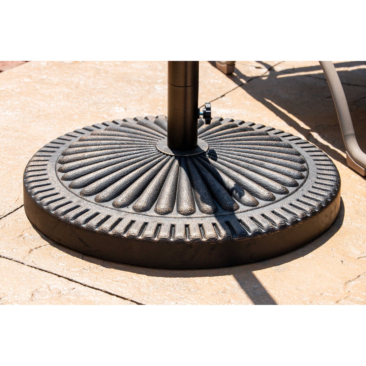 Island Umbrella 31-lb Base - fluted bronze base holding a pole on a stone-flagged patio