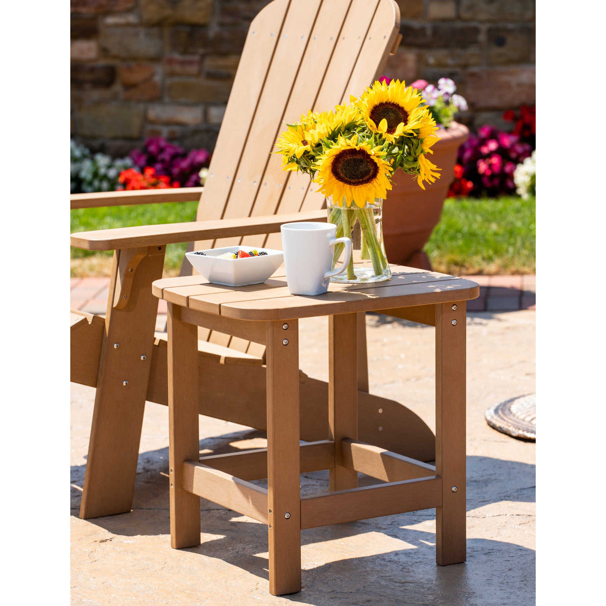 Island Retreat Adirondack Side Table, Teak - table beside a chair holding flowers and a mug