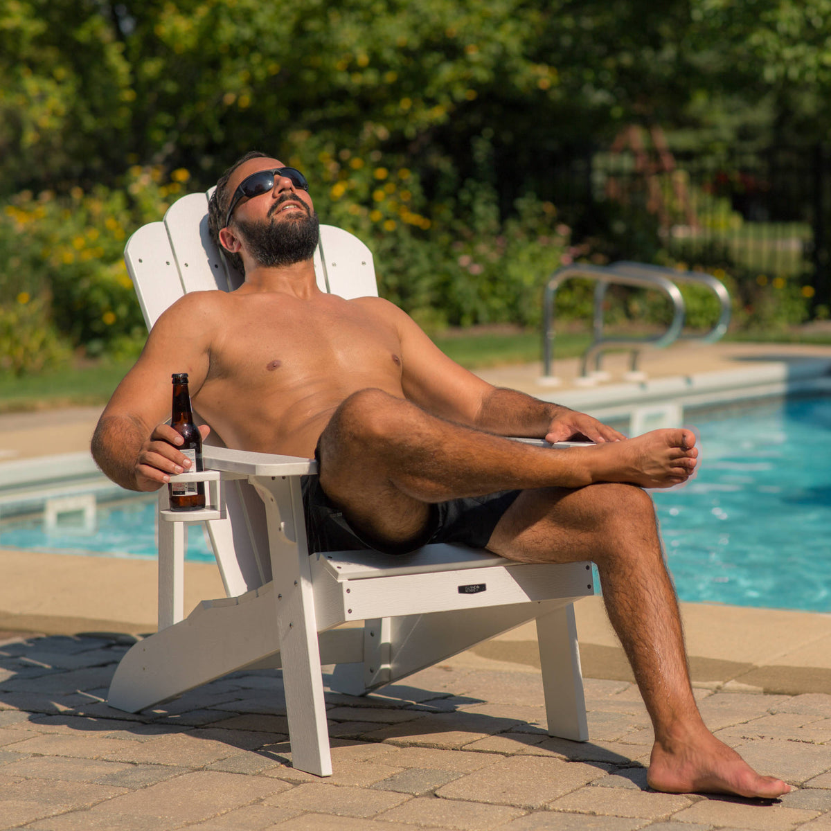Island Retreat Tek-Wood Adirondack Chair - swimmer reclining in the chair beside a pool