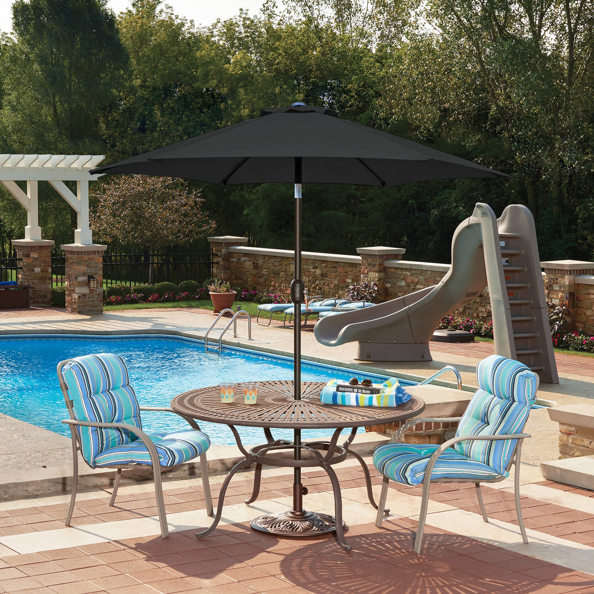 Island Umbrella Bistro Hexagon Market Umbrella - black canopy shading a poolside dining set