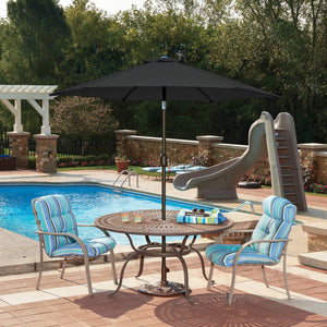Island Umbrella Bistro Hexagon Market Umbrella - black canopy shading a poolside dining set